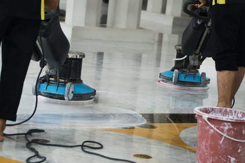 Workers operating buffing machines cleaning polished marble floor