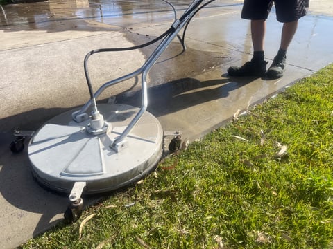 Worker using pressure washer to clean surface remove dirt